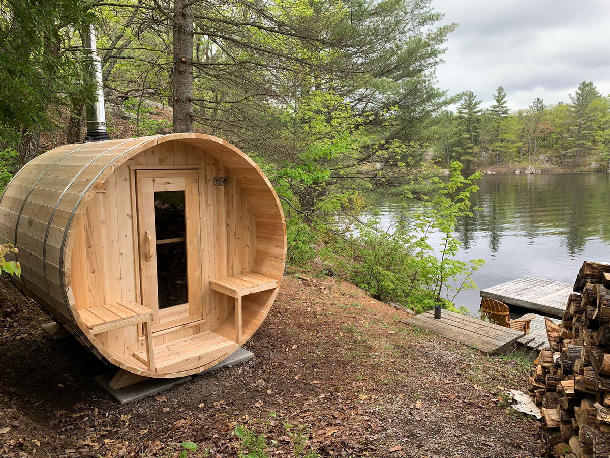 Leisurecraft CT Serenity CTC2245W barrel sauna beside a wooded lake